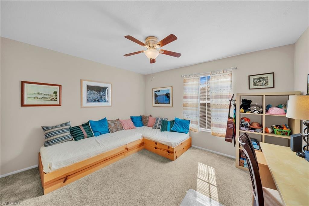 Living room featuring light colored carpet and ceiling fan
