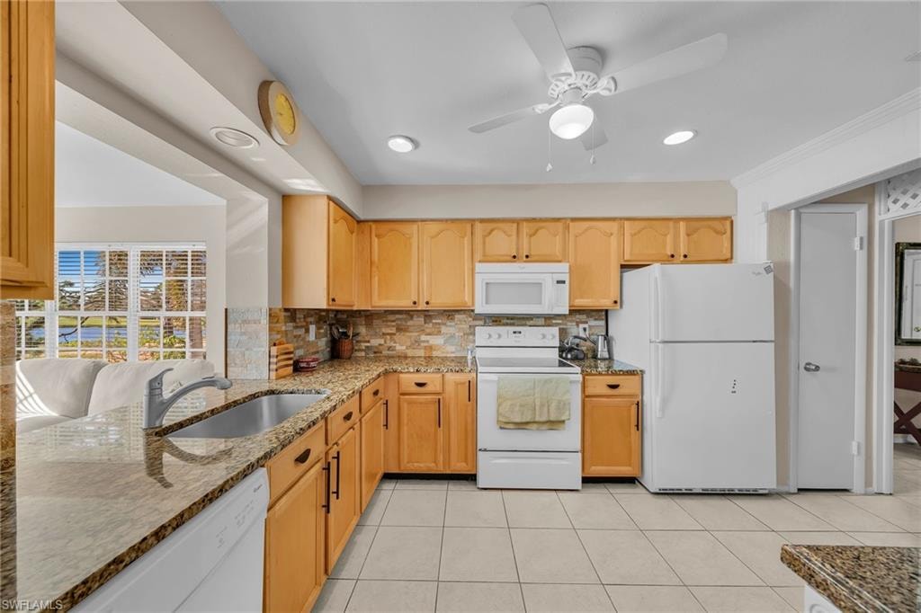Kitchen featuring white appliances, light stone countertops, a ceiling fan, tasteful backsplash, and recessed lighting
