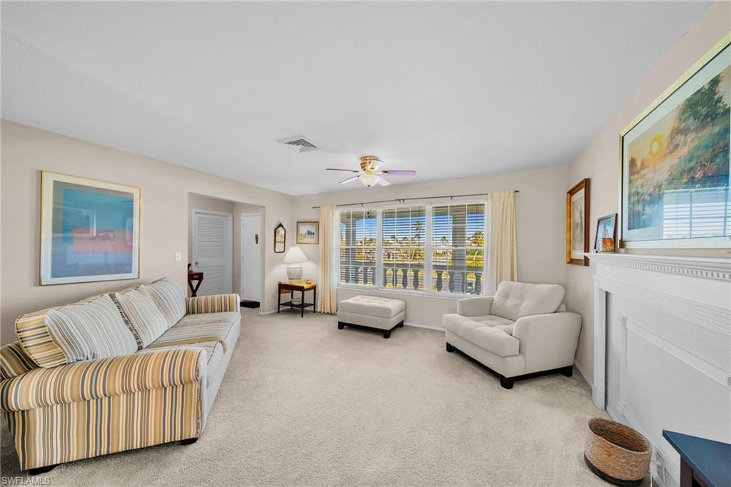 Living room with a ceiling fan and light colored carpet