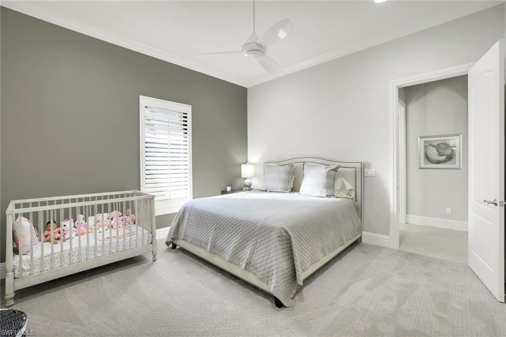 Bedroom featuring crown molding, light carpet, and a ceiling fan