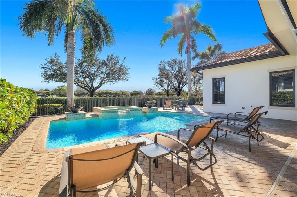 Integrated pool / hot tub featuring a patio area and a fenced backyard