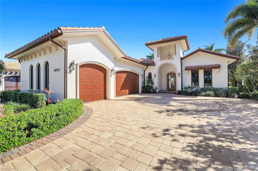 Mediterranean / spanish home featuring a garage, decorative driveway, stucco siding, and a tiled roof