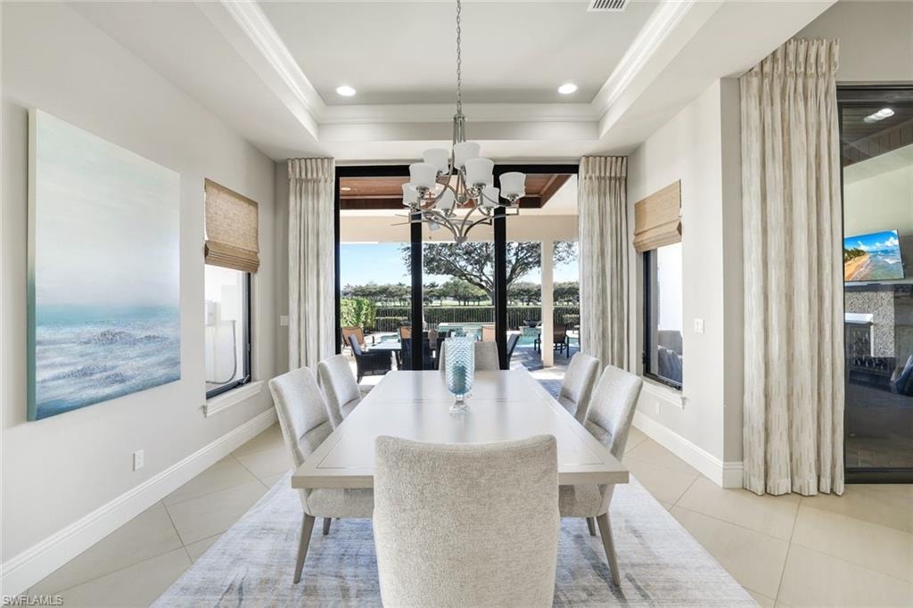 Dining space with hanging lights, crown molding, and light tile patterned floors