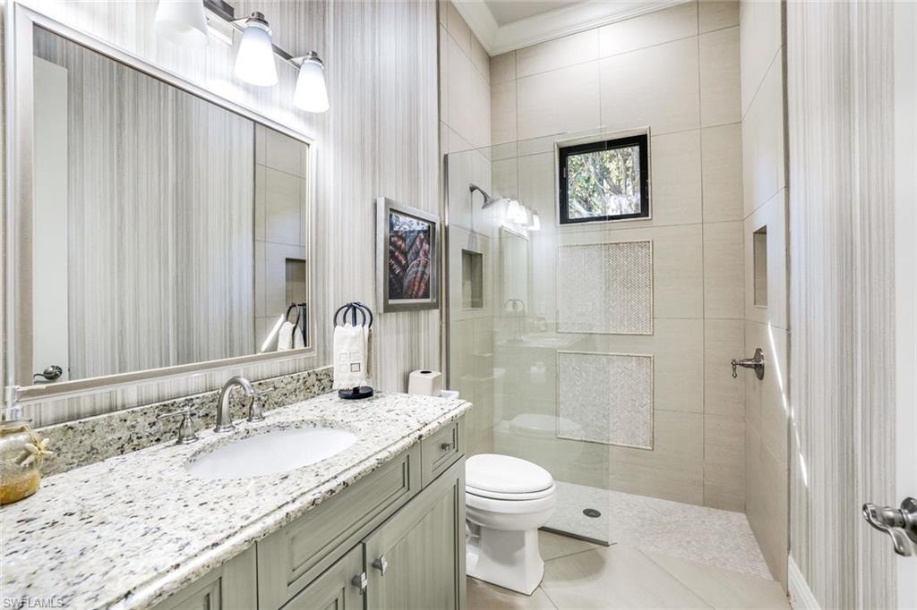 Bathroom featuring vanity, a walk in shower, and light tile patterned floors