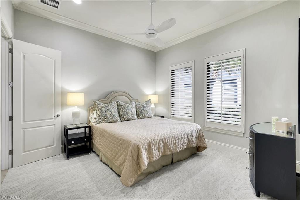 Bedroom featuring crown molding, light colored carpet, and ceiling fan