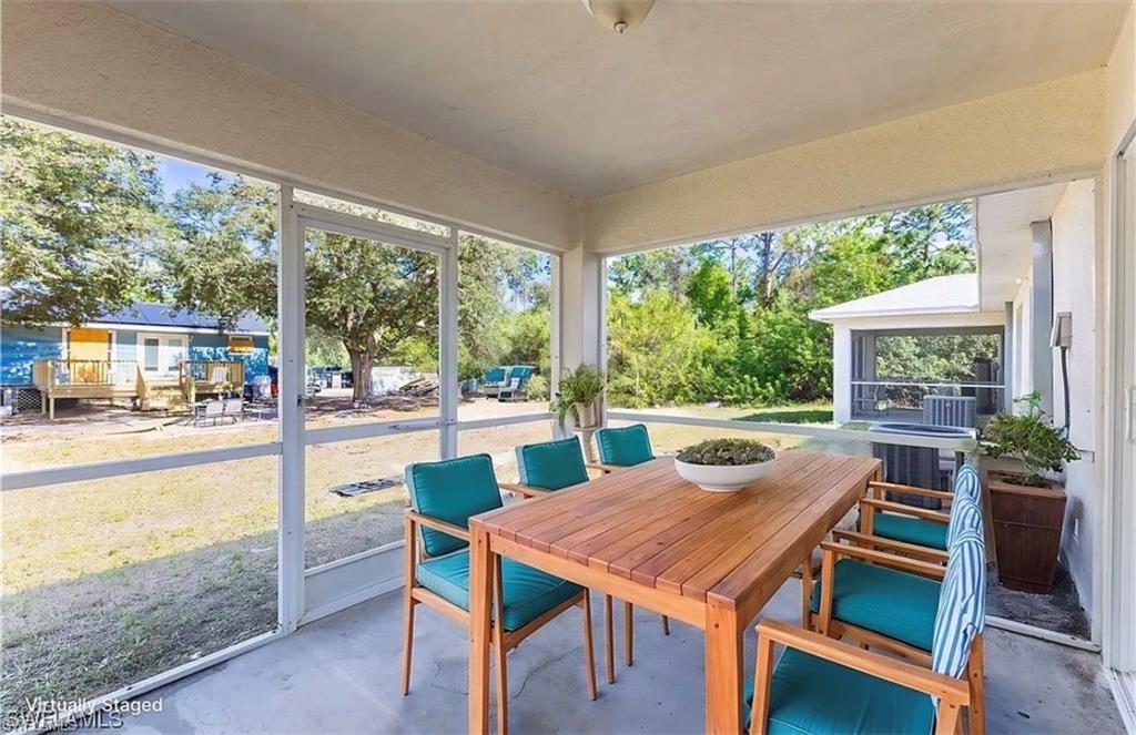 Sunroom with outdoor dining space and a patio area