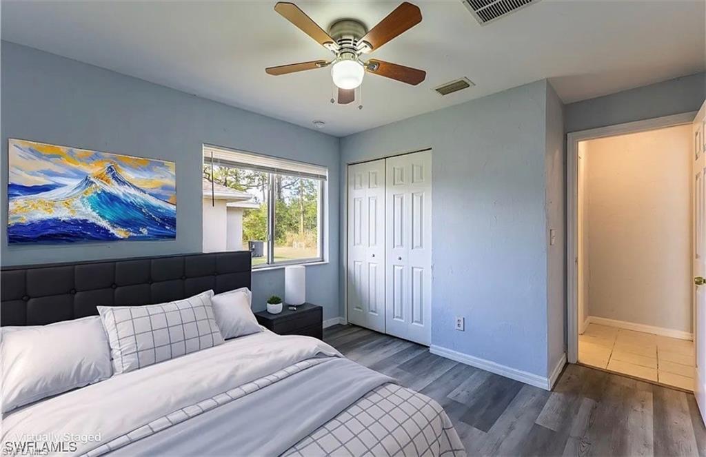 Bedroom featuring wood finished floors, a closet, and ceiling fan
