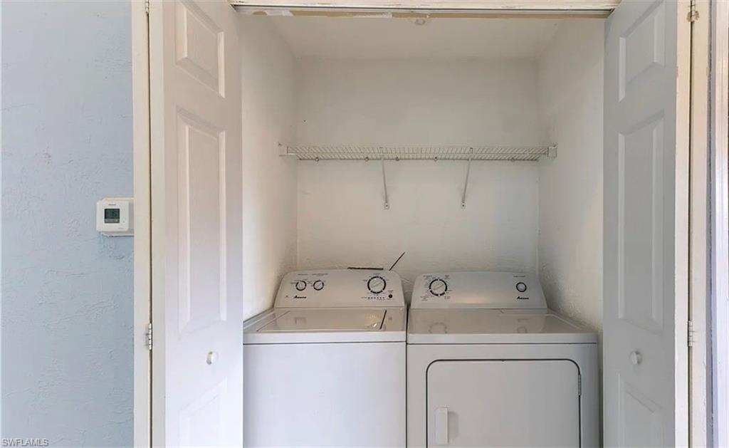Laundry area with washing machine and clothes dryer and a textured wall