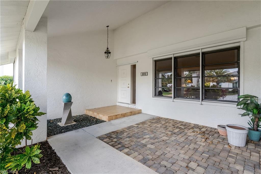 Entrance to property with a porch and stucco siding