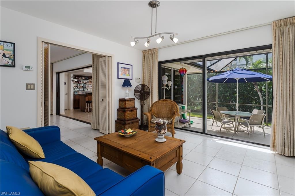 Living room featuring a sunroom and light tile patterned flooring