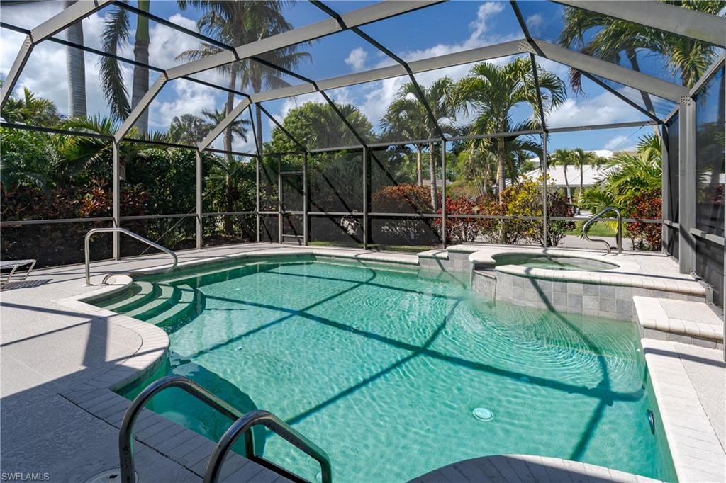 Relaxing pool / spa with a sunroom, a patio, and glass enclosure