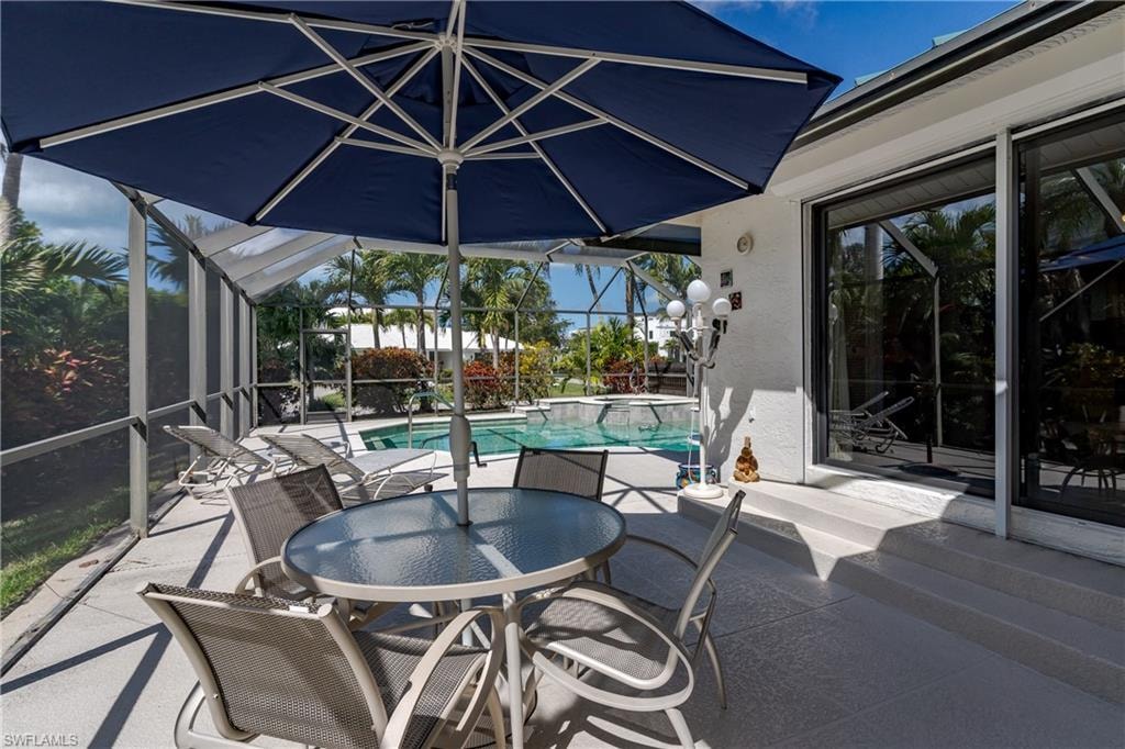 View of patio / terrace with outdoor dining area, a pool with connected hot tub, a lanai, and a sunroom