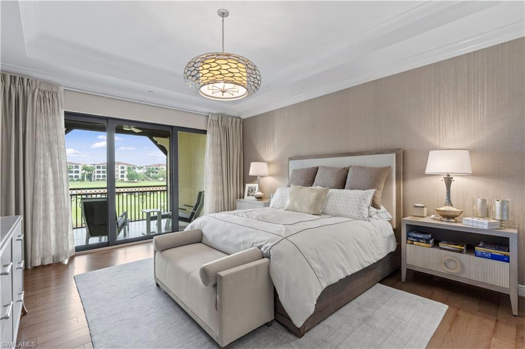Bedroom with access to exterior, hardwood / wood-style flooring, crown molding, a raised ceiling, and wallpapered walls