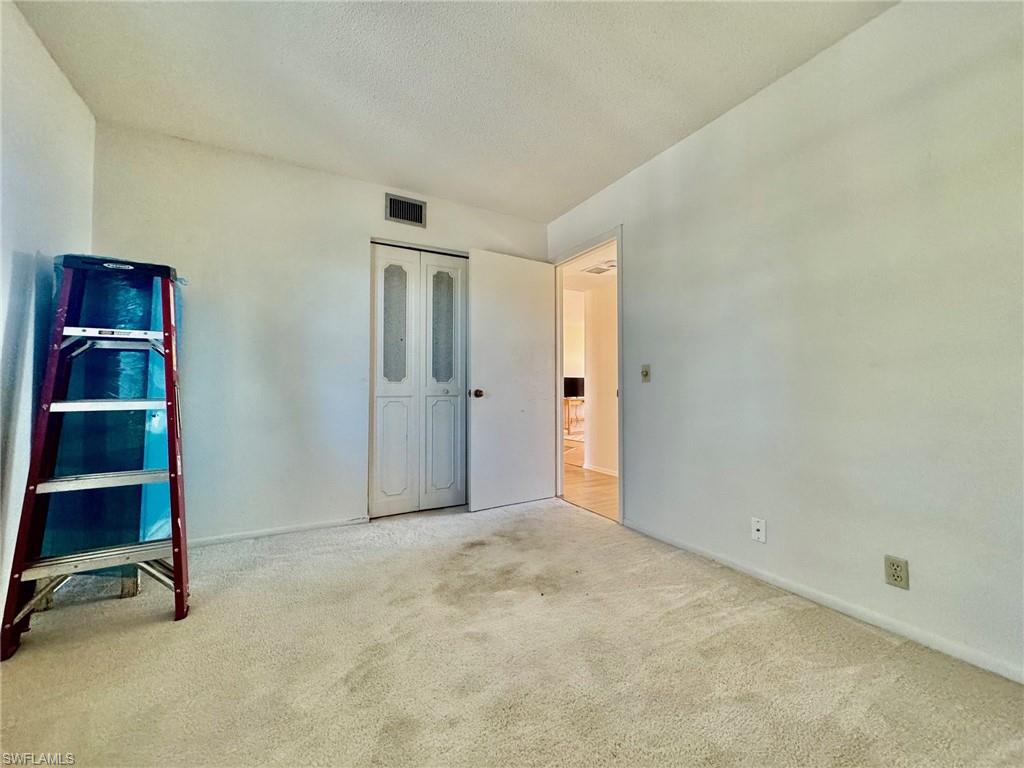 Unfurnished bedroom featuring carpet, a textured ceiling, and a closet