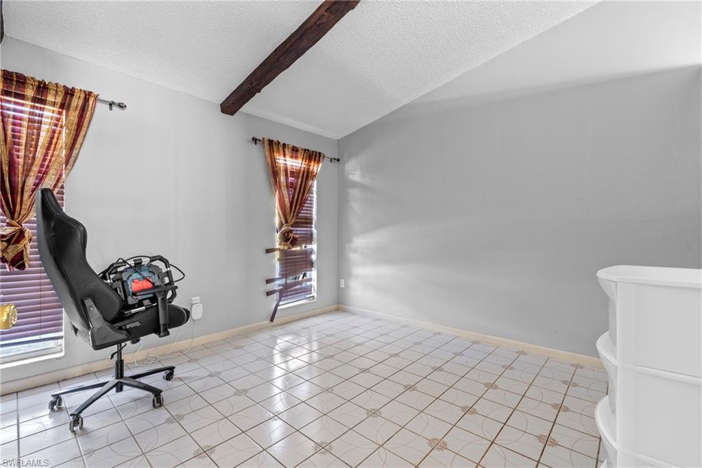 Home office featuring beamed ceiling and light tile patterned floors