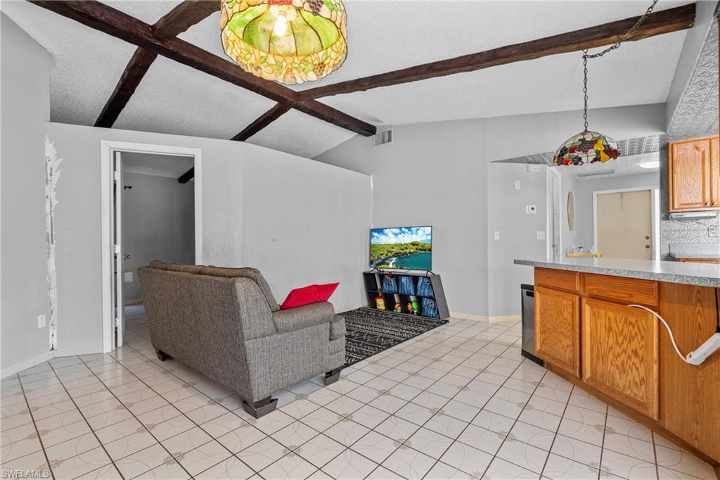 Living room with light tile patterned floors and coffered ceiling