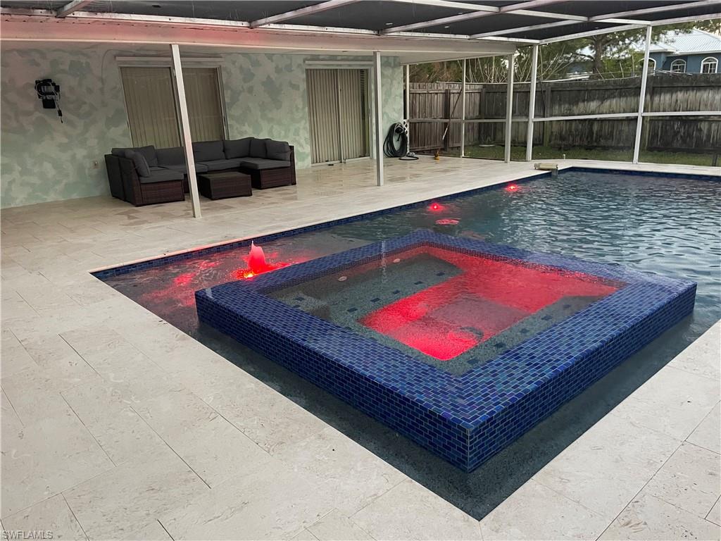 Integrated pool / spa featuring a patio area, glass enclosure, and an outdoor lounge area