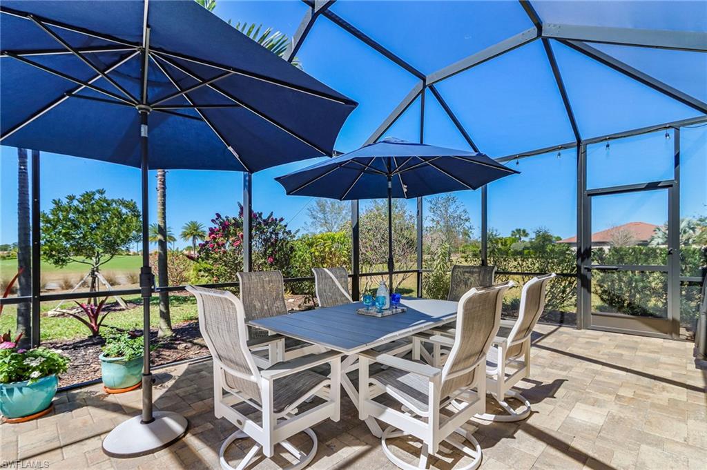 View of patio with a lanai, outdoor dining space, and a sunroom