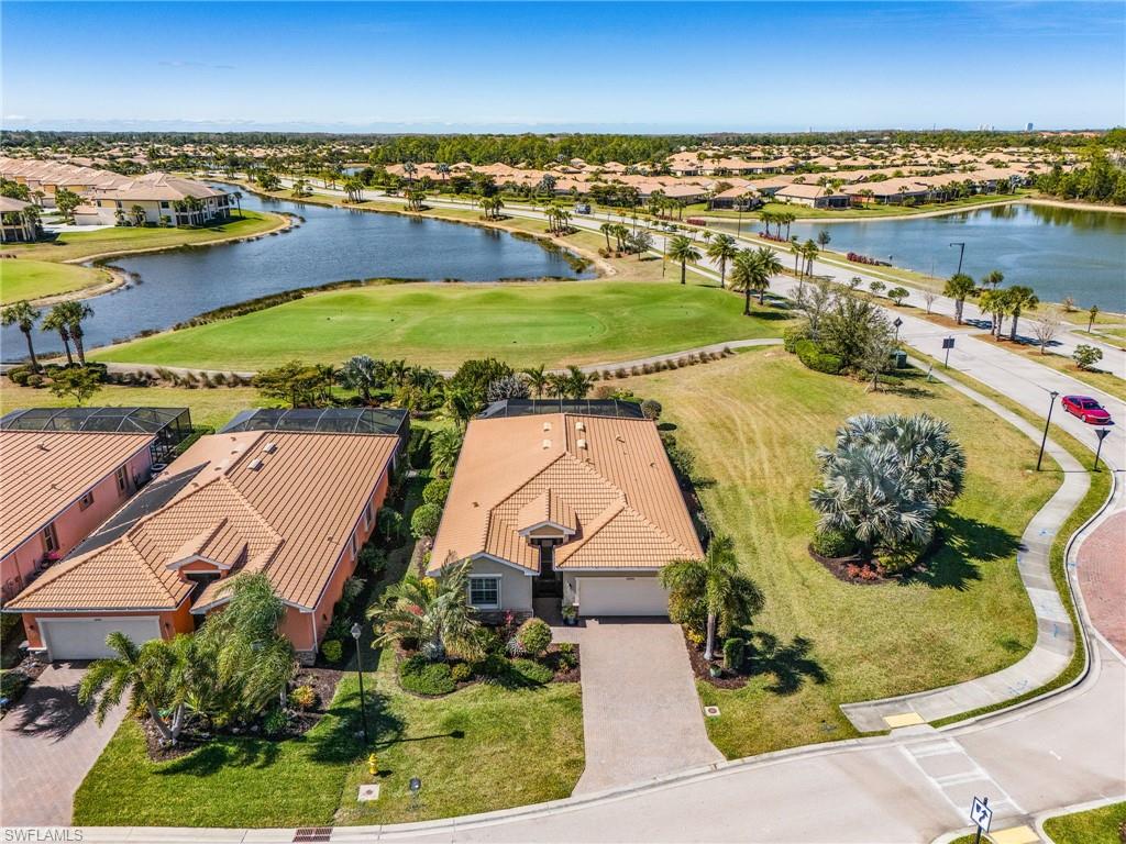 Aerial view of residential area with a nearby body of water and a golf club