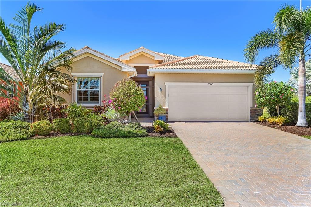 View of front of house featuring decorative driveway, an attached garage, stucco siding, and a tiled roof