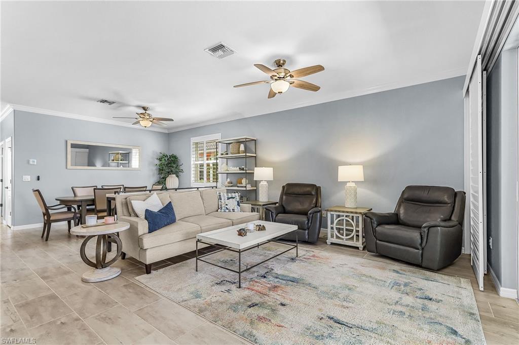 Living area featuring ceiling fan and crown molding