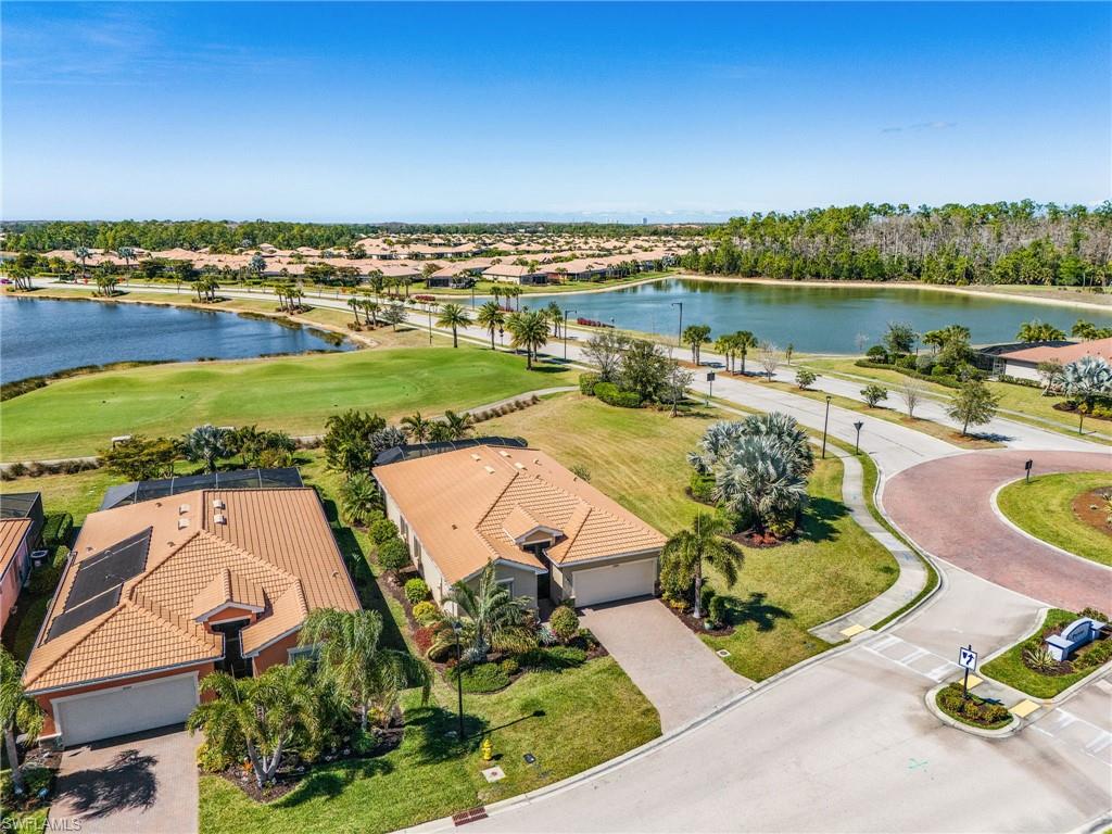 Aerial view of residential area with a nearby body of water and a golf club