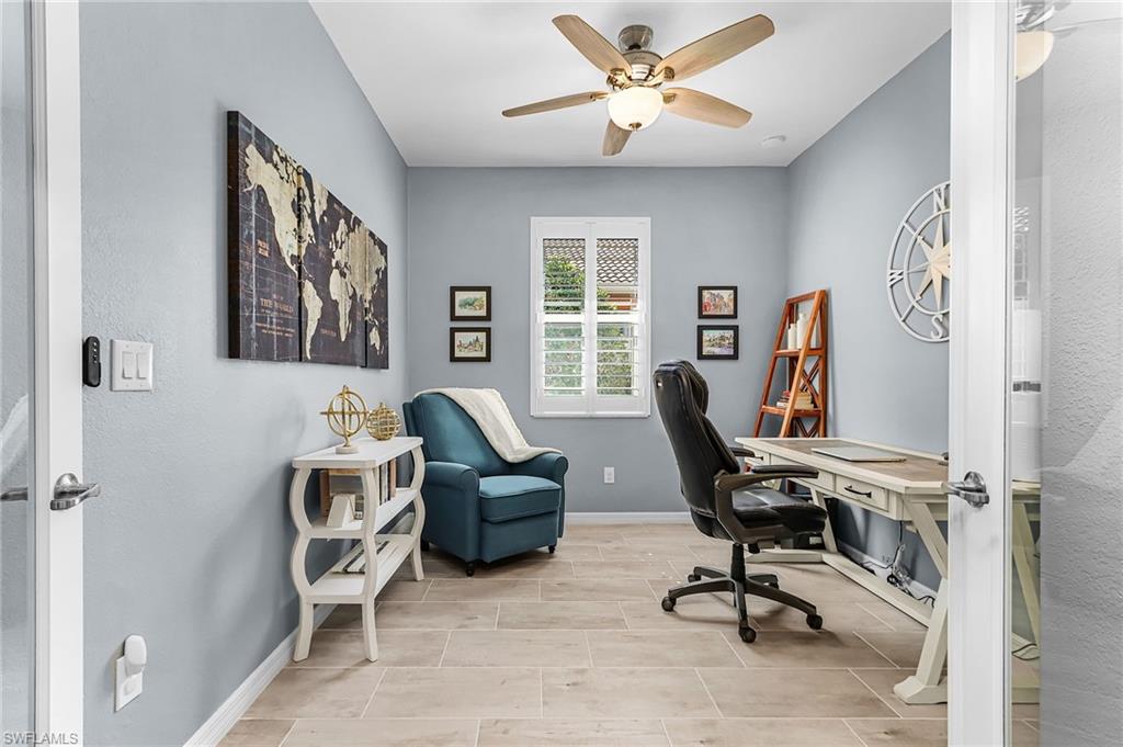 Home office with a ceiling fan and wood tiled floors