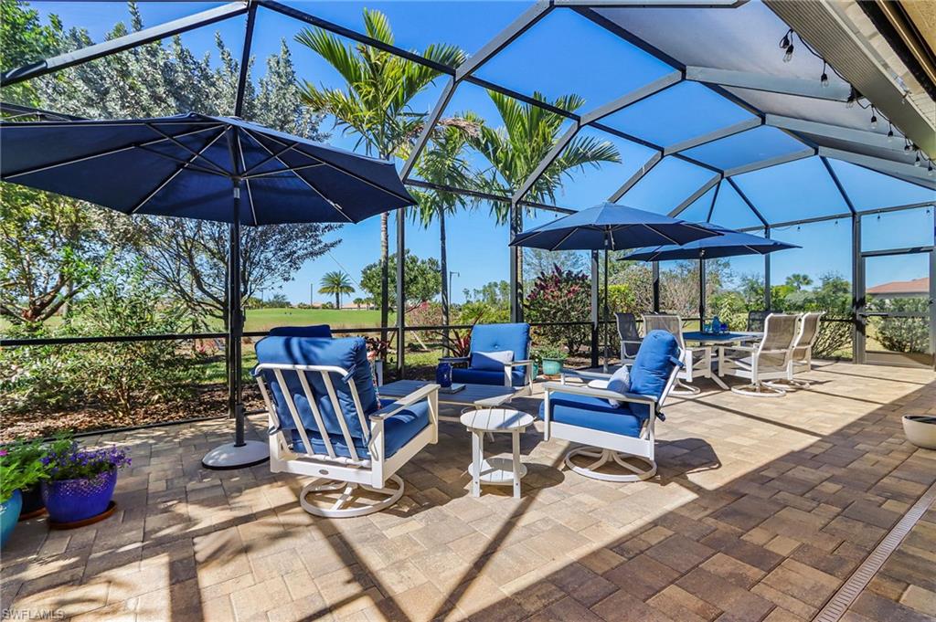 View of patio / terrace featuring a sunroom, a lanai, and an outdoor living / dining area