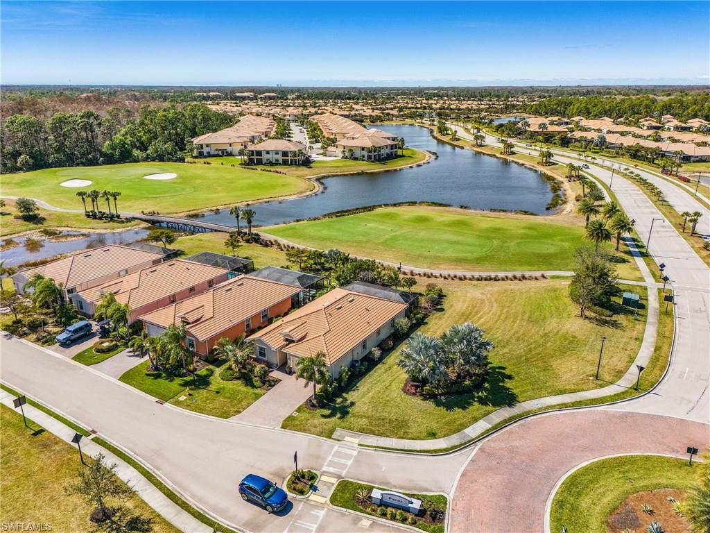 Aerial view of residential area featuring a golf course and a large body of water