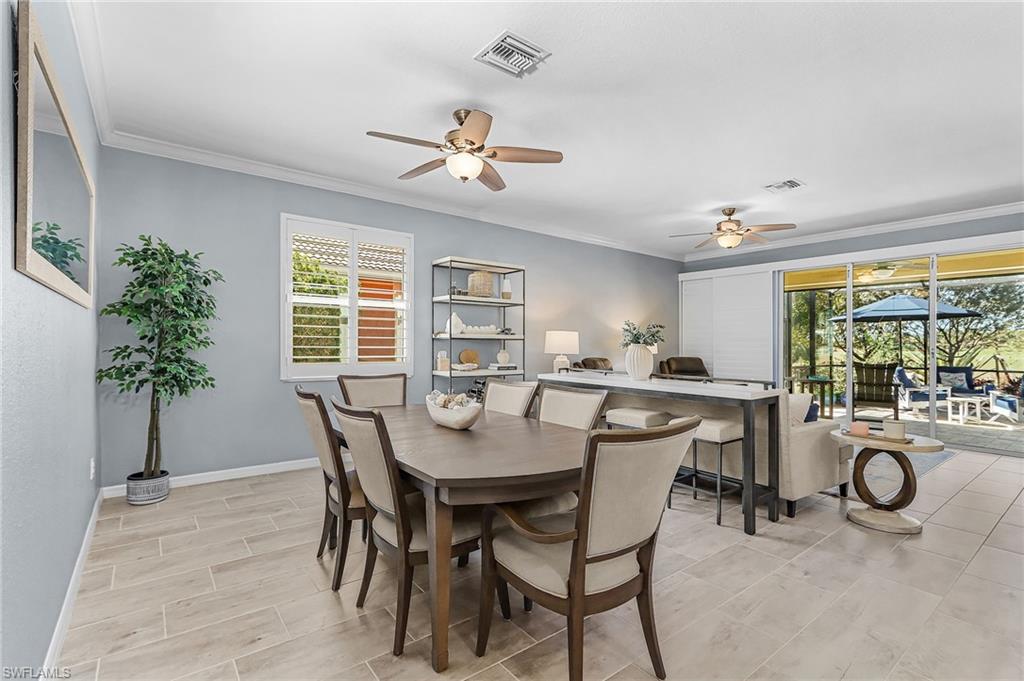 Dining room with crown molding, ceiling fan, and wood tiled floors