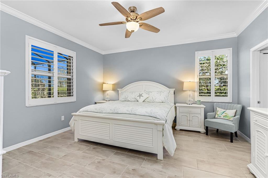 Bedroom with ceiling fan and ornamental molding