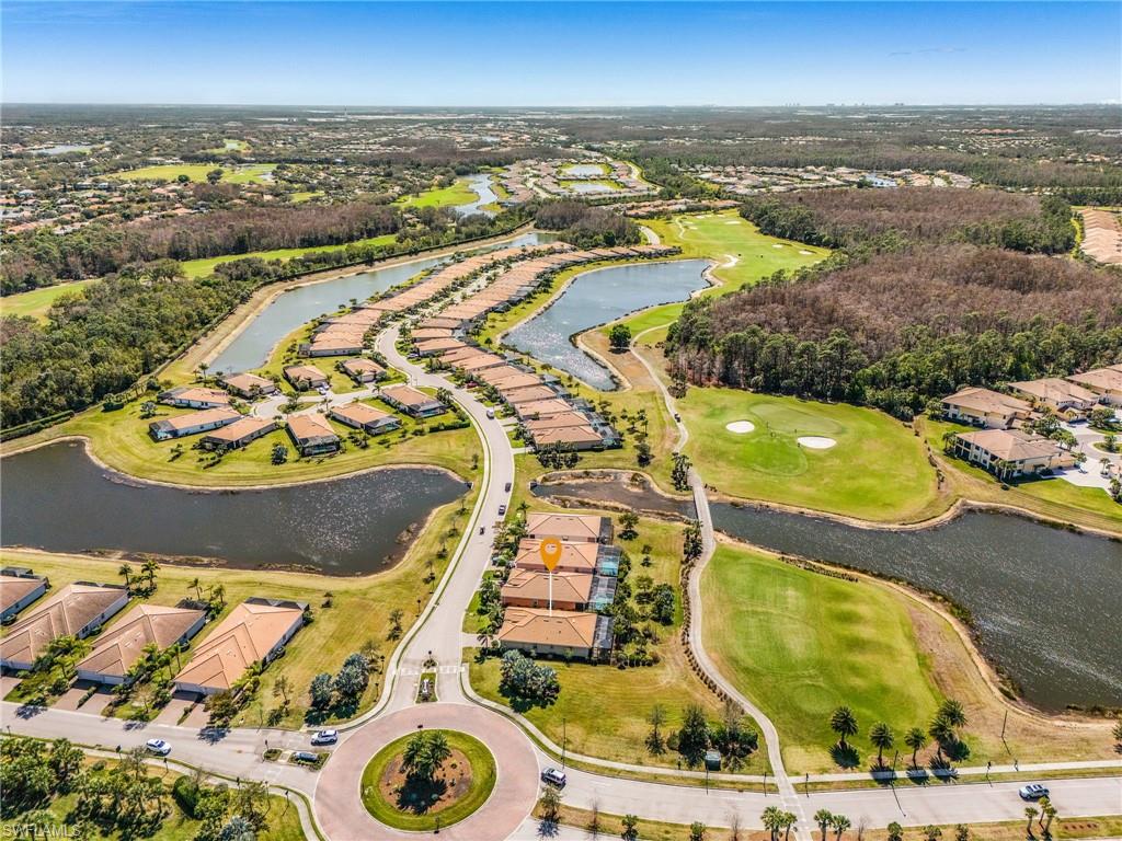 Aerial view of property's location with nearby suburban area, a nearby body of water, and a golf course