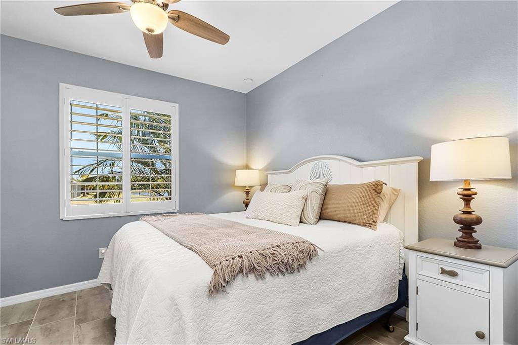 Bedroom with a ceiling fan, wood tiled floors, and vaulted ceiling