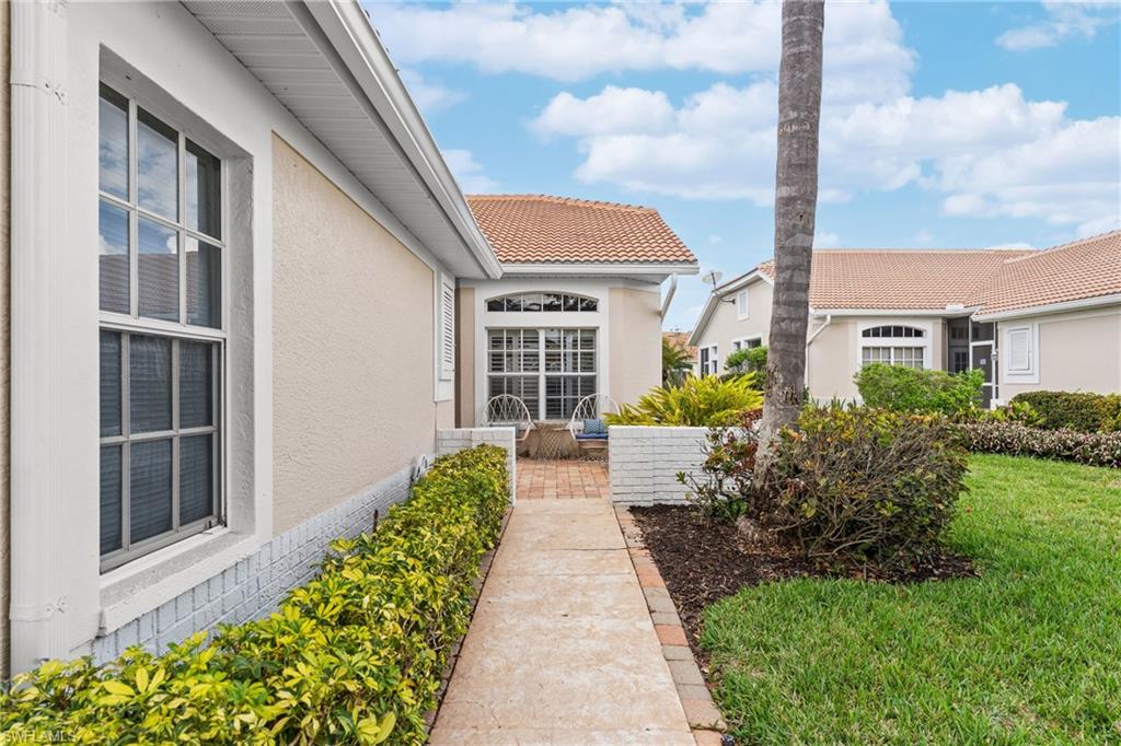 Property entrance featuring stucco siding, a tile roof, and a yard