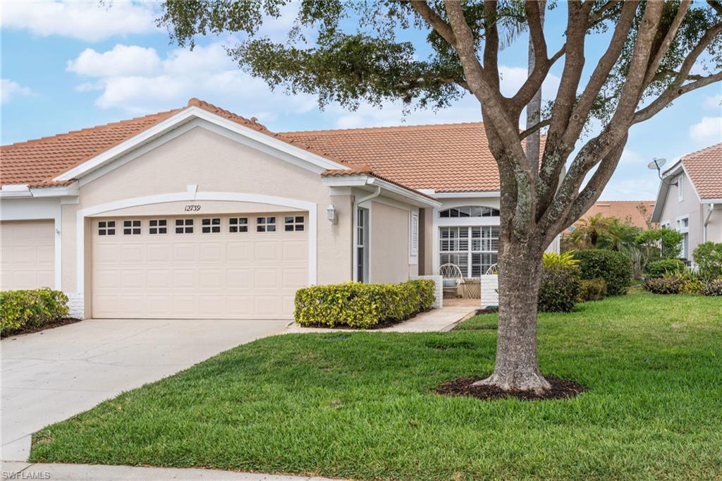 Mediterranean / spanish-style home with a tile roof, a front yard, stucco siding, driveway, and an attached garage
