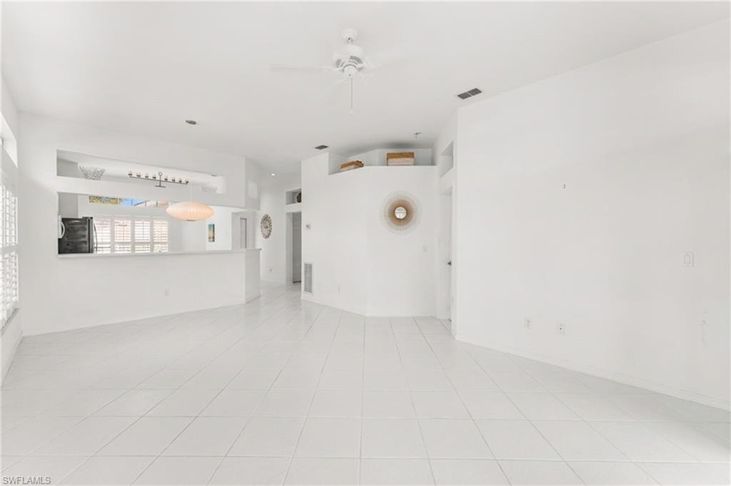 Unfurnished room featuring ceiling fan and light tile patterned flooring