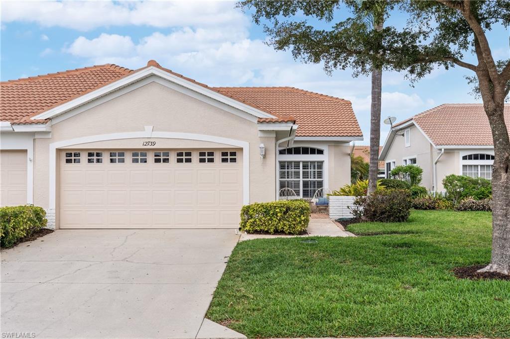 Mediterranean / spanish-style house featuring a tiled roof, an attached garage, stucco siding, and a front yard