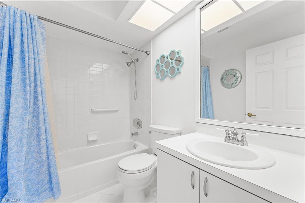 Full bathroom featuring vanity, shower / tub combo with curtain, and light tile patterned flooring