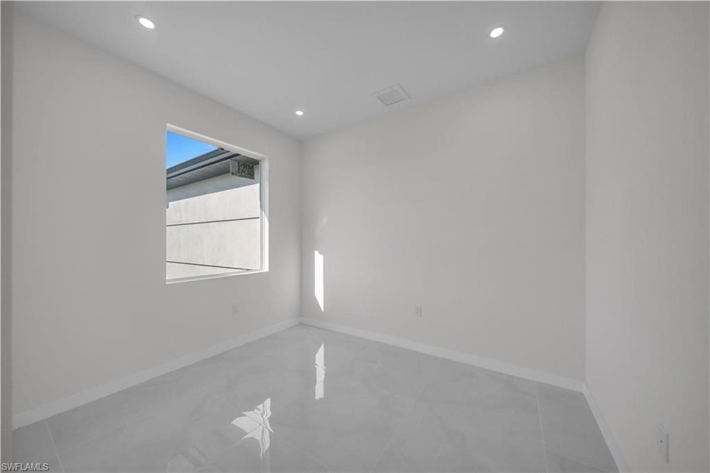 Empty room featuring recessed lighting and baseboards