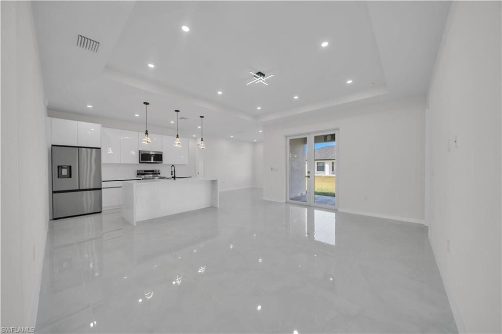 Unfurnished living room with recessed lighting and baseboards