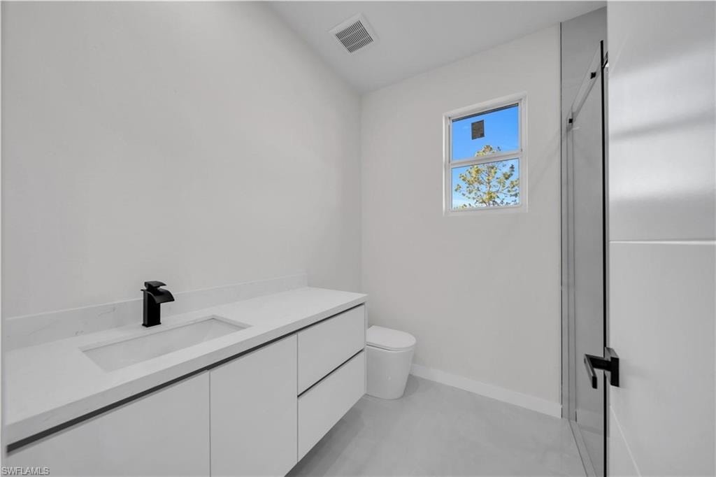 Bathroom with vanity, a shower stall, and finished concrete flooring