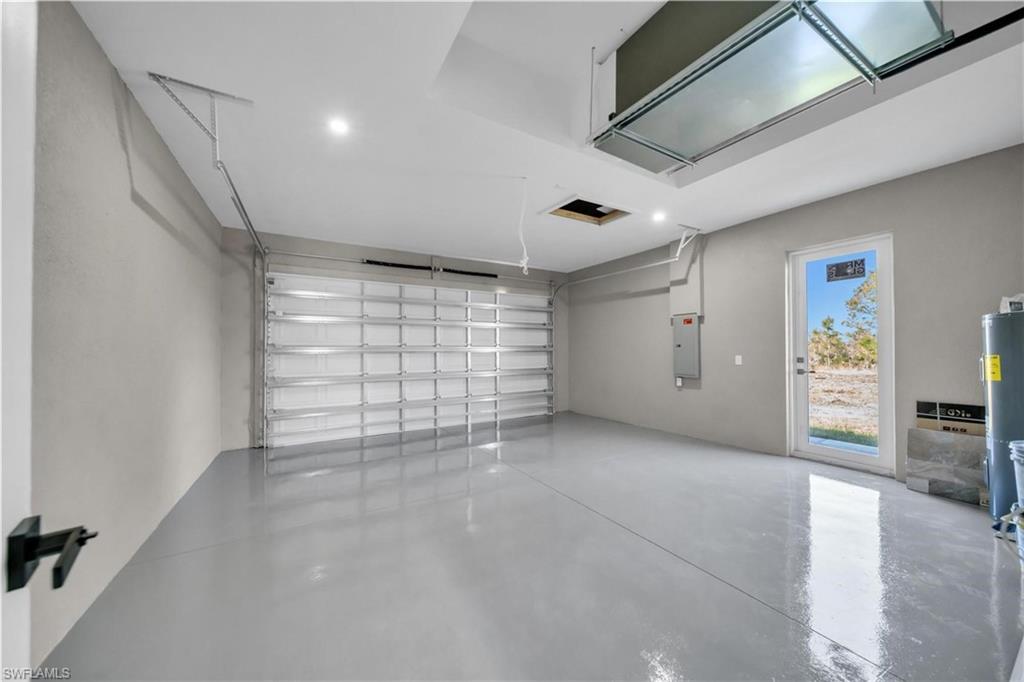 Garage featuring water heater and electric panel
