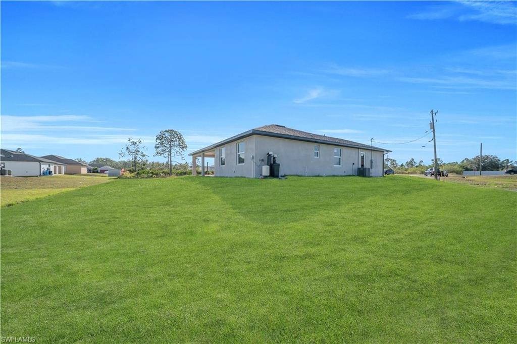 View of side of home with a yard and stucco siding