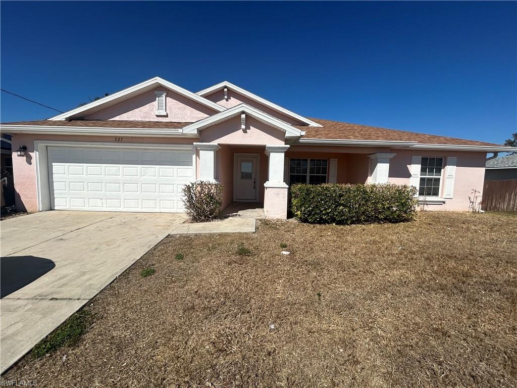 Single story home with an attached garage, stucco siding, and concrete driveway