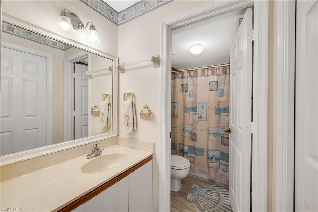 Full bathroom with vanity, a shower with shower curtain, and light wood-style floors