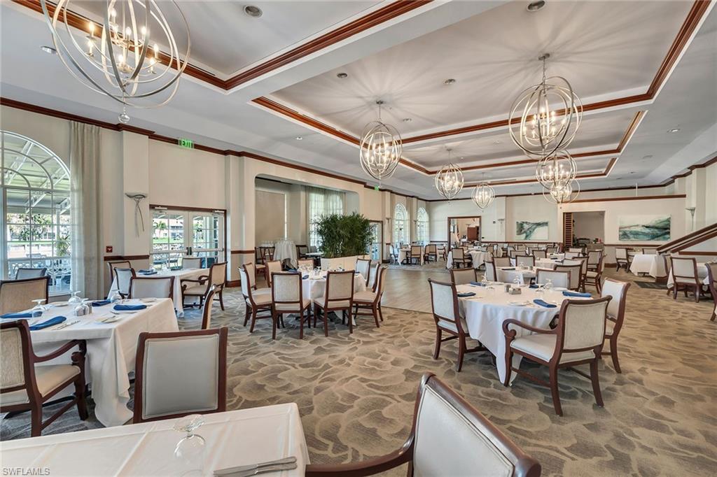 Dining room featuring hanging lights, crown molding, and a tray ceiling