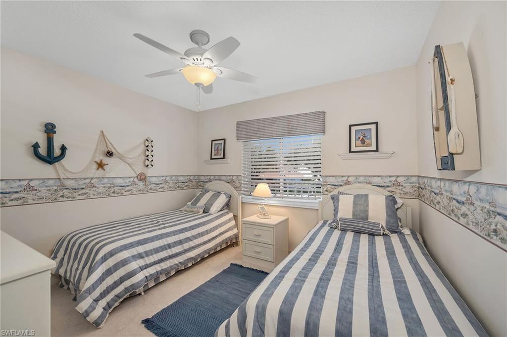 Bedroom with light carpet and a ceiling fan