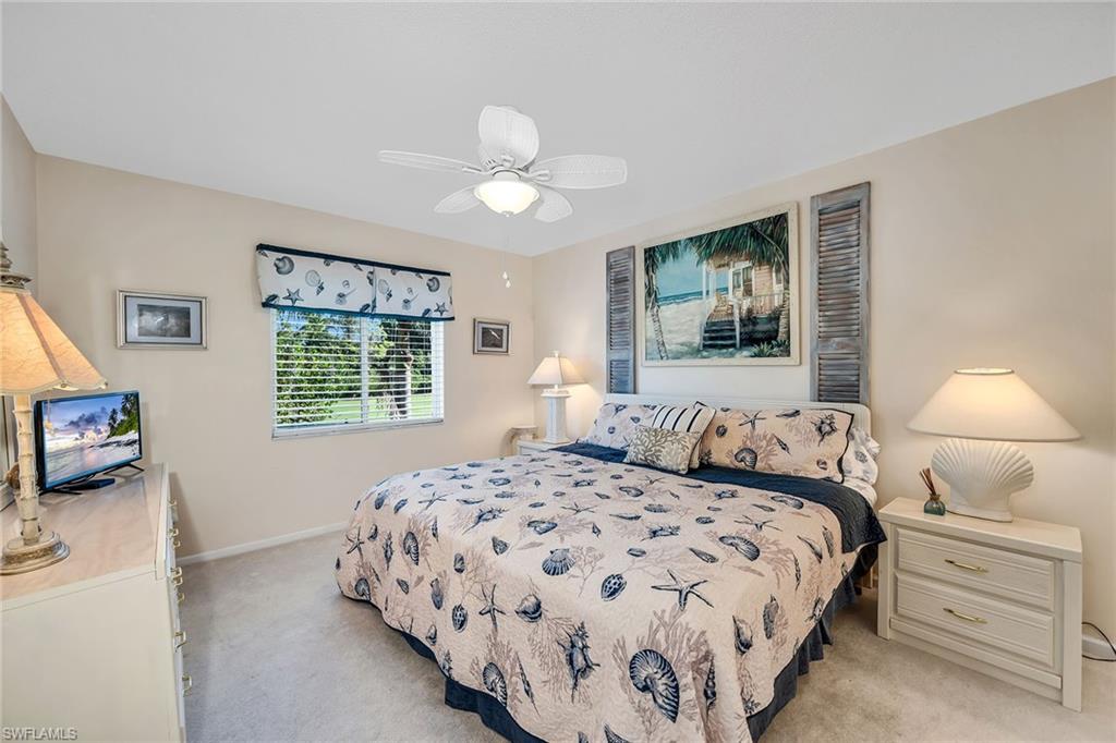 Bedroom with light colored carpet and a ceiling fan
