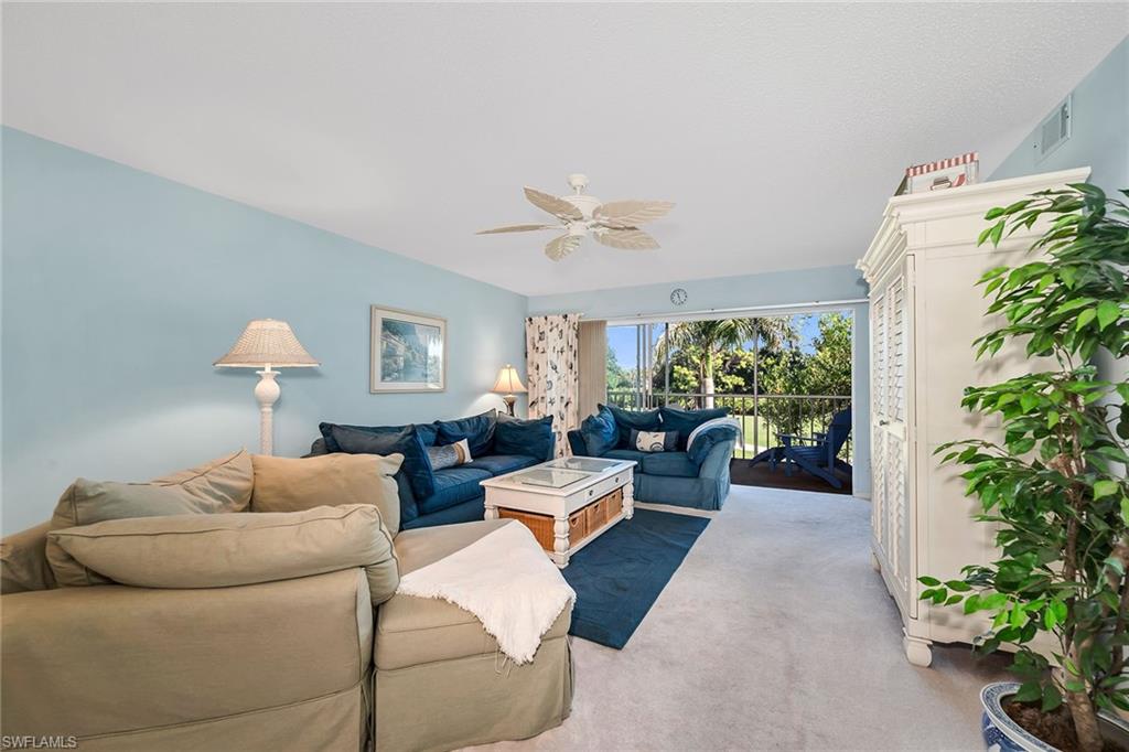 Carpeted living room featuring a ceiling fan