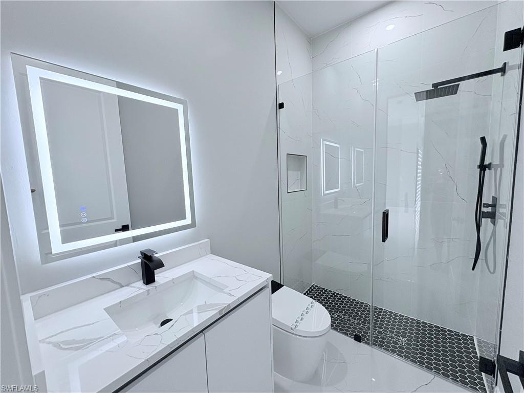 Full bathroom with vanity and a marble finish shower